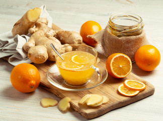 Cup of ginger tea with honey and lemon on wooden table, still life, horizontal orientation