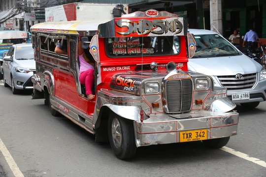 MANILA, PHILIPPINES - NOVEMBER 25, 2017: People ride a jeepney public transportation in heavy traffic in Manila, Philippines. Metro Manila is one of the biggest urban areas in the world.
