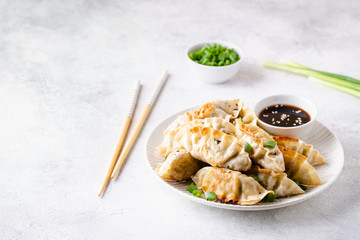 Fried dumplings gyoza with soy sauce, and chopsticks.