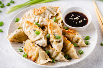 Fried dumplings gyoza with soy sauce, and chopsticks.