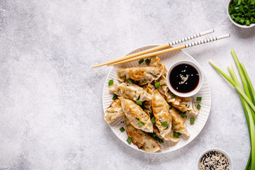 Fried dumplings gyoza with soy sauce, and chopsticks.