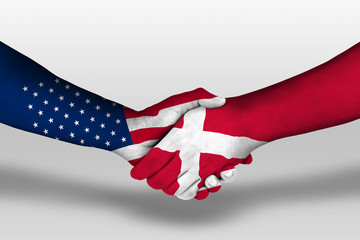 Handshake between denmark and united states of america flags painted on hands, illustration with...
