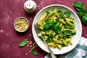 Penne pasta with green pea and basil pesto. Top view with copy space.