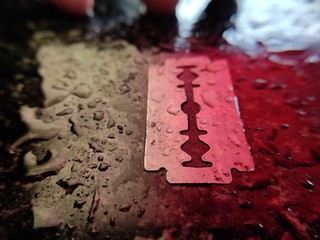 Water droplets on razor (blade) with colourful light 