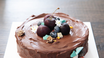 Tasty chocolate fudge cake with fresh cherry for decoration