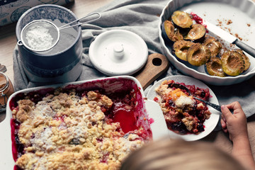 Homemade cake with plum and fruit with healthy ingredient tasted by little girl.  Vegetarian...