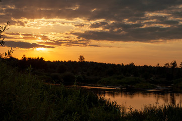Obraz premium orange sunset over the river. sunset over the river. beautiful warm summer red sunset