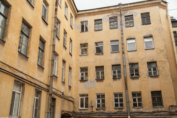 The courtyard of an old apartment building in St. Petersburg with yellow shabby walls