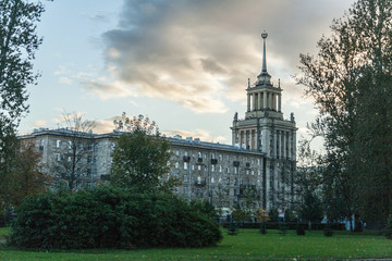 Fototapeta na wymiar Vintage house in the Stalinist Empire style with a spire next to the autumn park