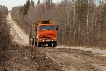 Obraz na płótnie Canvas Orange empty Russian timber truck on a dirt road
