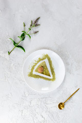 A slice of chocolate mint cake with matcha on a white plate. Sugar, lactose, gluten free. Vertical orientation, top view.