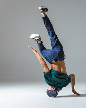 Cool guy breakdancer dancing on one hand isolated on gray background. Breakdance poster