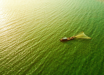 Aerial view of Ben Nom fishing village, a brilliant, fresh, green image of the green algae season on Tri An lake, with many traditional fishing boats anchored