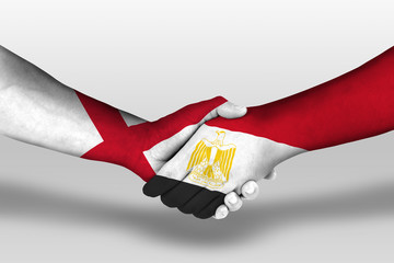 Handshake between egypt and england flags painted on hands, illustration with clipping path.