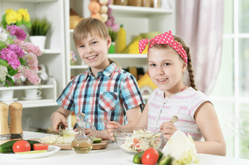 Cute brother and sister cooking together in kitchen