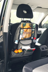 Travel organizer with different things on car seat in salon