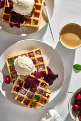 Baked traditional Belgium waffles with ice cream and cherries. Breakfast.