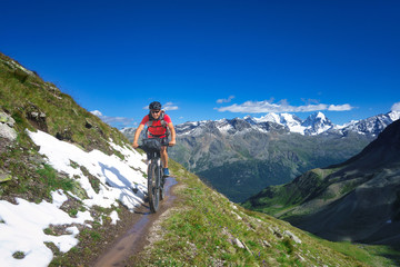 Fototapeta na wymiar Biker on mountain trail in beautiful landscape on the alps