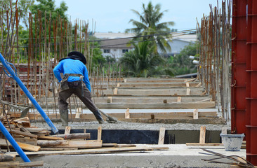 Construction workers are using the newly poured cement spreaders of crane into the ground to allow ordinary cement concrete with a thickness determined by the engineer and a smooth uniform surface.