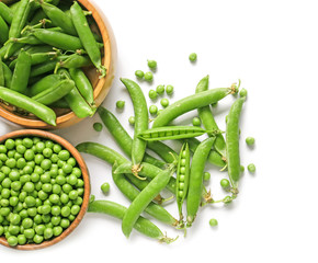 Bowls with tasty fresh peas on white background