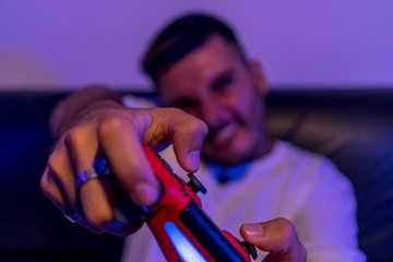 Chico joven jugando a la consola y comiendo palomitas
