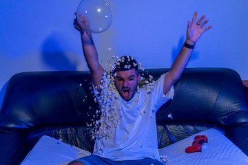 Chico joven jugando a la consola y comiendo palomitas © MiguelAngelJunquera