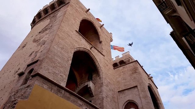 Historical city gate - Torres de Quart and waving flags