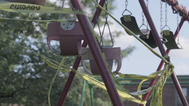 Closed swing set strung up around due to pandemic. Slomo, static
