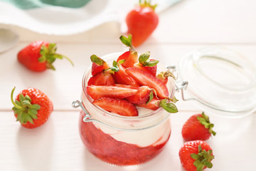Jar of strawberry yogurt on table