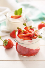 Jar of strawberry yogurt on table