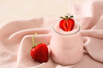 Jar of strawberry yogurt on table