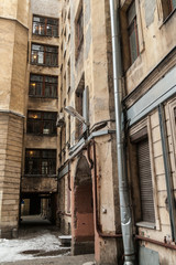 The courtyard of an old apartment building in St. Petersburg with yellow shabby walls