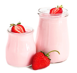 Jars of strawberry yogurt on white background