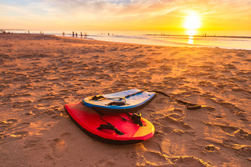 Swimming bodyboards on the beach at beautiful sunset on a warm summer evening, South Australia