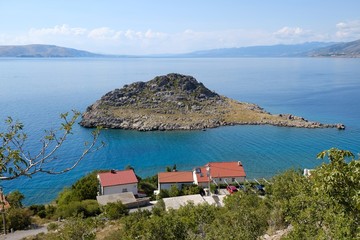Fototapeta na wymiar Beautiful view of Sveti Juraj, Croatia. A small quiet port village on the Adriatic with crystal clear water. View from viewpoint to rocky coast with houses by the sea.