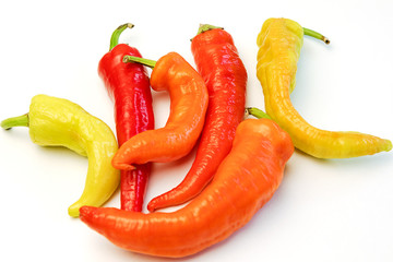 yellow, orange and red hot peppers on a white table. Concept of the harvest season, bright autumn.