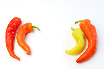 yellow, orange and red hot peppers on a white table. Concept of the harvest season, bright autumn.