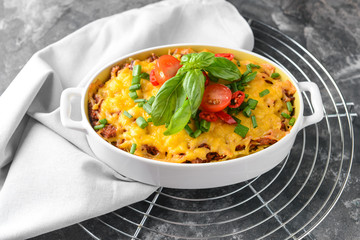 Baking dish with tasty beef casserole on dark background