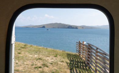 view of the lake through the door of the tourist trailer. selective focus. Travel concept.