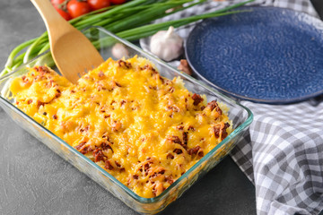 Baking dish with tasty beef casserole on dark background