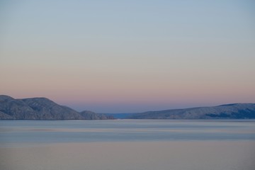 Idyllic view of rocky islands on horizon at dawn.