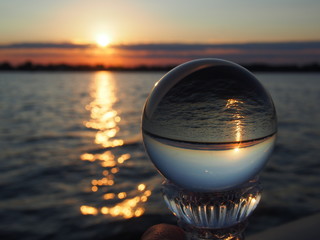 Round Glass Sphere Reflecting a Lake Sunset