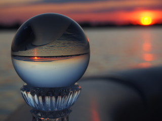 Round Glass Sphere Reflecting a Lake Sunset