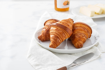 Breakfast with croissants, tea and orange jam.