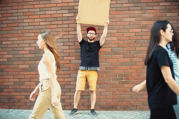 Dude with sign - man stands protesting things that annoy him. Solo demonstration his right to talk free on the street with sign. Copyspace for text. Opinion heard by public. Social life, humor, meme.