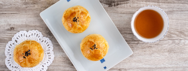 Moon cake yolk pastry, mooncake for Mid-Autumn Festival holiday, top view design concept on bright wooden table with copy space, flat lay, overhead shot