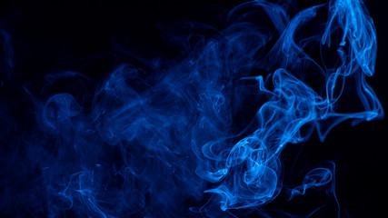 Conceptual image of blue color smoke isolated on dark black background, Halloween design element concept.