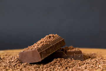 Pieces of chocolate on wooden table sprinkled with chocolate chips