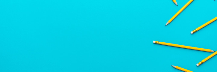 Top view photo of yellow sharpened pencils over turquoise blue background with copy space. Flat lay...