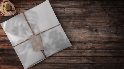 White Package with Paper Tag Mockup – Wooden Table and Beer Bottle Background – Top View